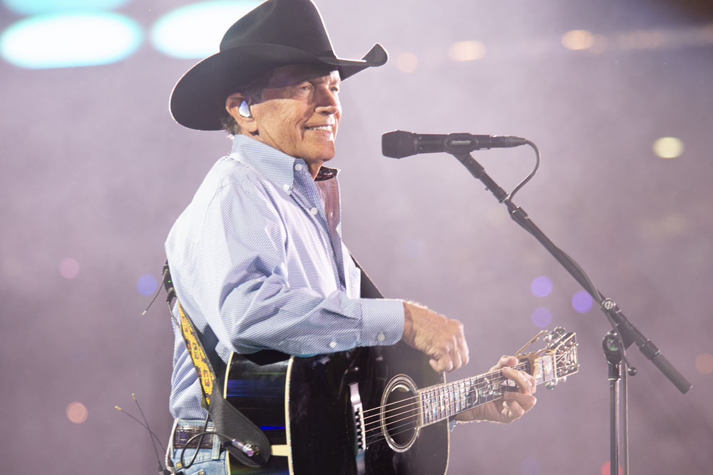 George Strait Playing guitar on stage.